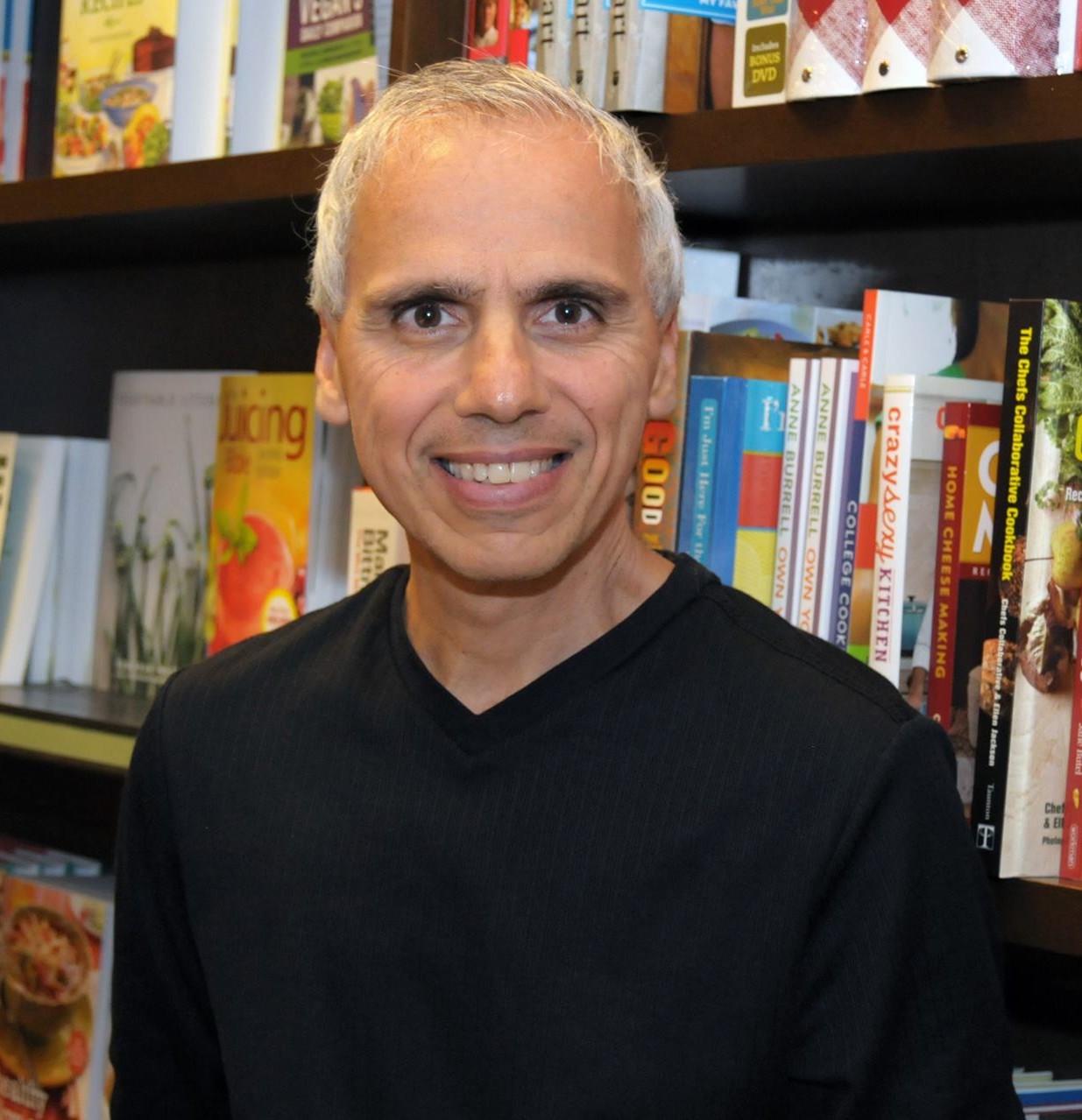 Herbie J Pilato smiling in front of bookshelves