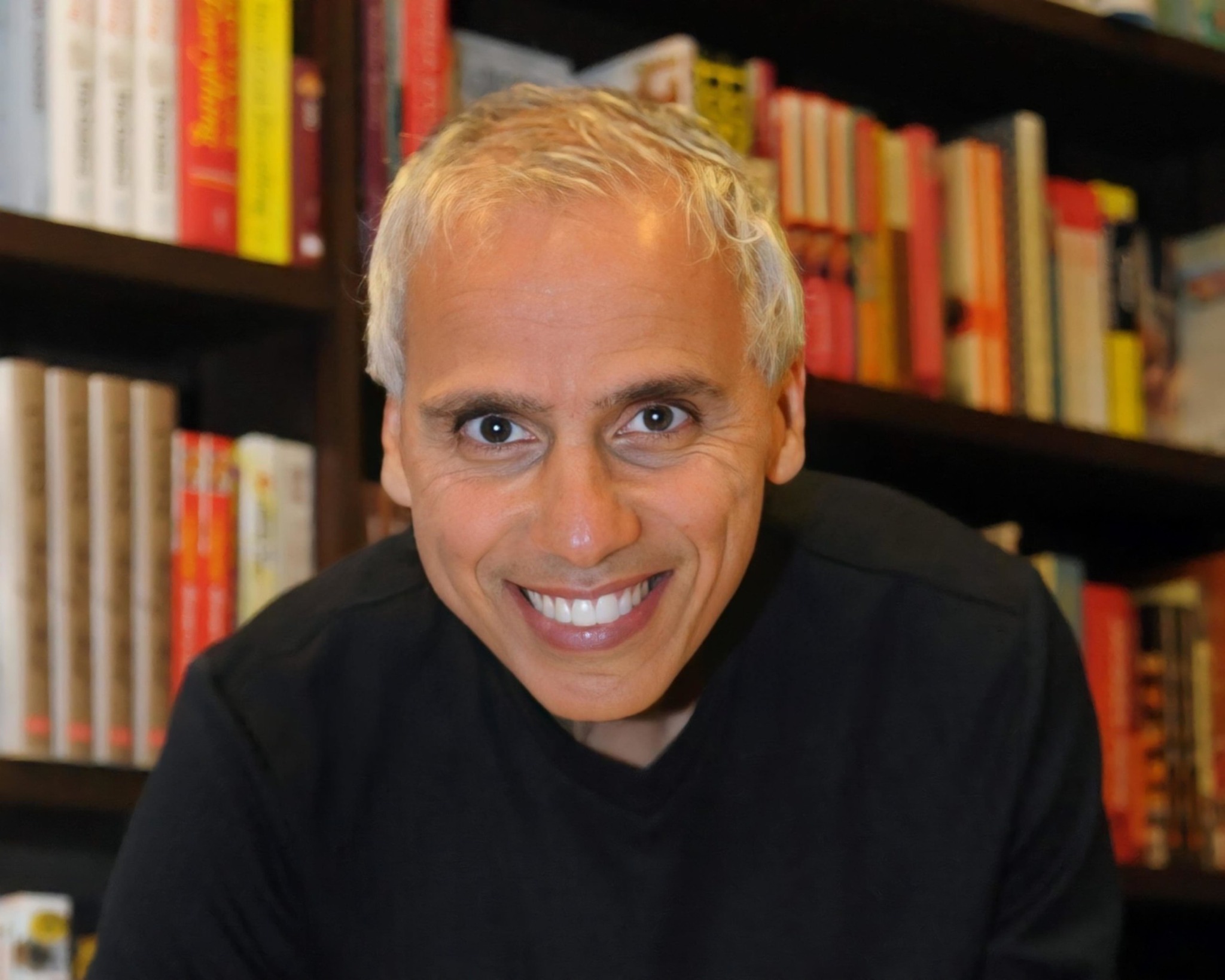 Herbie J Pilato smiling in front of bookshelves