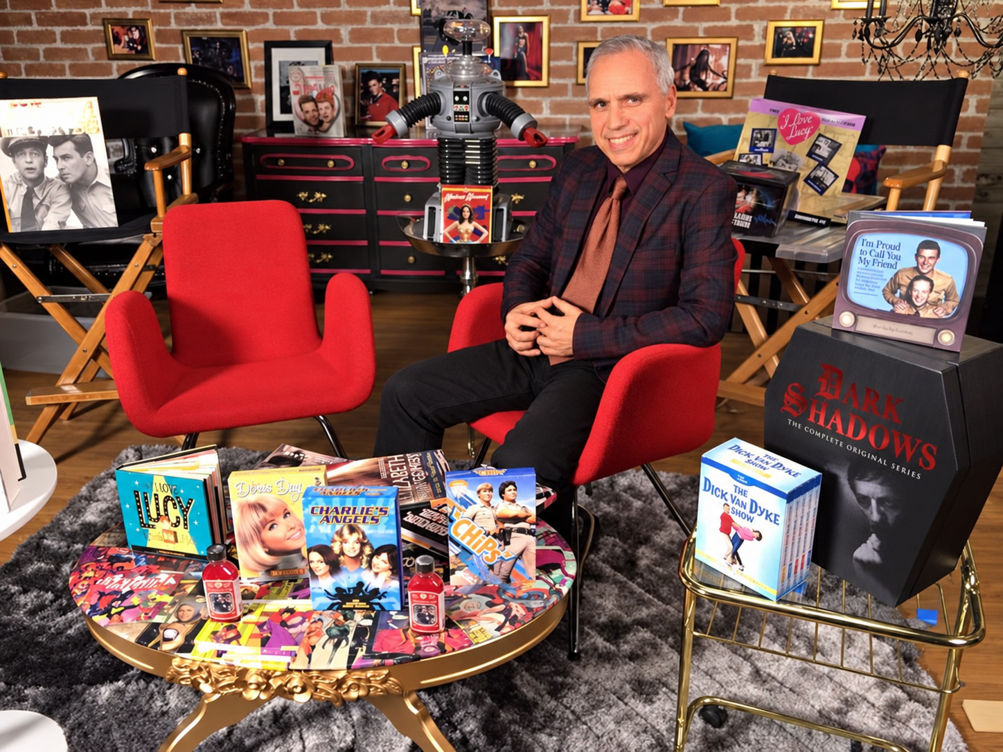 Herbie J Pilato seated on the Then Again set among classic television memorabilia